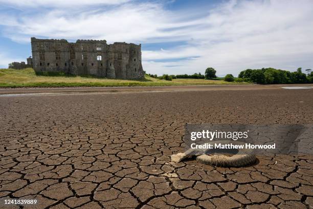 An old wheel is exposed on the riverbed at low tide in the Carew River which runs alongside Carew Castle on July 11, 2022 in Pembrokeshire, Wales....