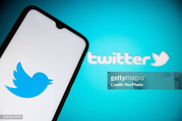 In this photo illustration a Twitter logo seen displayed on a smartphone screen with Twitter logo in the background in Athens, Greece on July 11,...