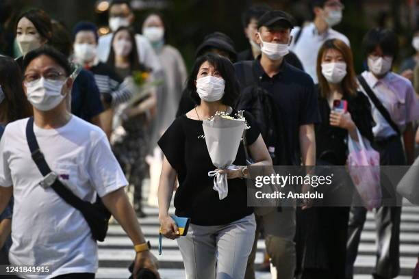 Woman carries a bouquet of flowers as she come to paying homage to Shinzo Abe, former prime minister of Japan, at the Tokyo Zojo-JI Temple on July 11...