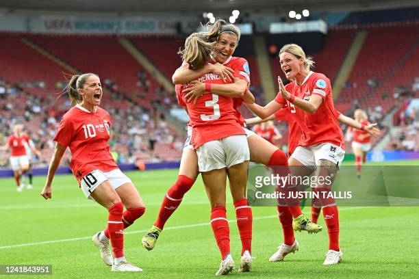 Austria's defender Katharina Naschenweng is mobbed by teammates after scoring the team's second goal during the UEFA Women's Euro 2022 Group A...