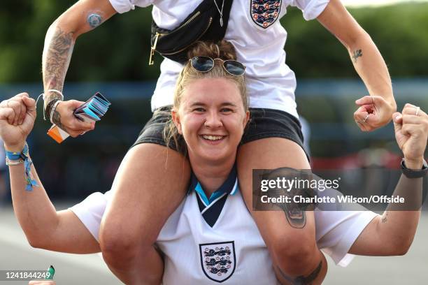 An England fan with a lion tattoo sits in the shoulders of a friend ahead of the UEFA Women's Euro England 2022 group A match between England and...