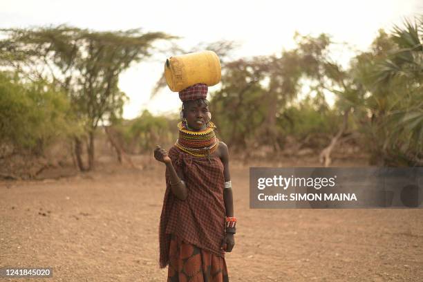 Turkana woman carries a jerrycan filled with water in the Loiyangalani area where families affected by the prolonged drought are hosted, at Parapul...