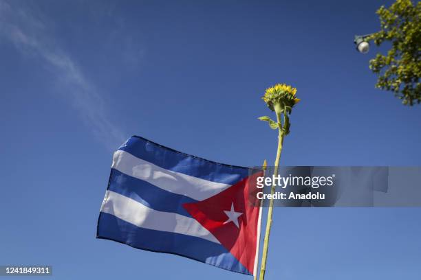 Cuban flag and a flower are seen during a gathering in Miami to support the freedom of the Cuban people as they commemorate the first anniversary of...