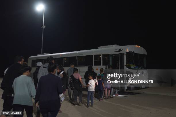 Border Patrol agents direct migrants to a bus for processing after illegally crossing the US-Mexico border in Yuma, Arizona, early in the morning of...