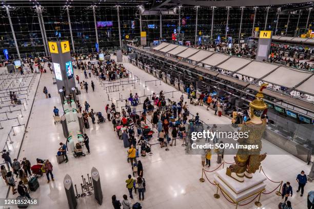 Large crowds of travelers wait to check in to their flights at Suvarnabhumi International Airport in Bangkok. Since the Thai Government lifted all...