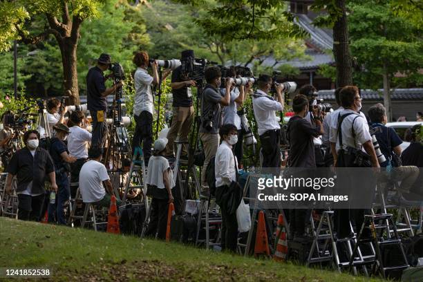 Media members cover the vigil of assassinated former Japanese Prime Minister Shinzo Abe from across Zojoji Temple at a nearby park after being denied...