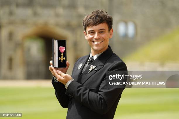 British diver and Olympic champion Tom Daley poses with his medal after being appointed an Officer of the Order of the British Empire for services to...