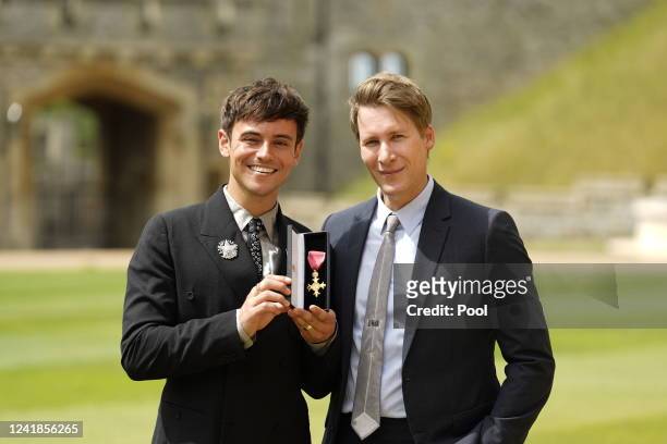 Tom Daley poses with his OBE for services to diving, as well as in recognition of his charity work and his support of LGBTQ+ rights next to his...
