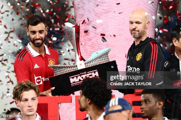 Manchester United's manager Erik Ten Hag and Manchester United's Portuguese midfielder Bruno Fernandes hold a trophy after the exhibition football...