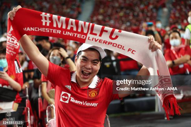 Fan of Manchester United holding up a half and half scarf during the preseason friendly match between Liverpool and Manchester United at Rajamangala...