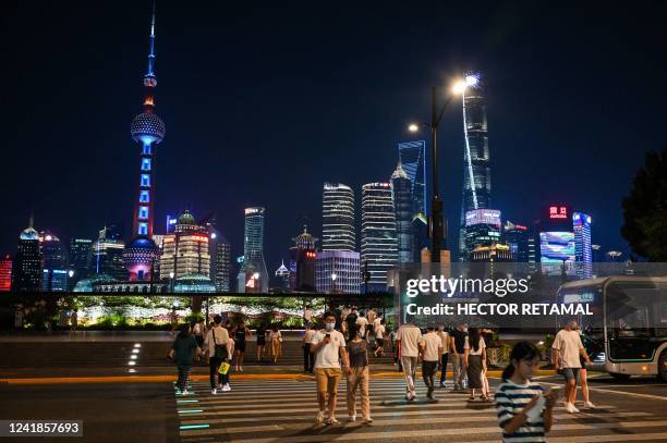 People walk on The Bund in the Huangpu district of Shanghai on July 12, 2022.