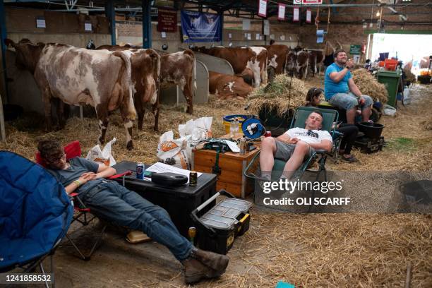 Exhibitors rest in a cow shed on the first day of the Great Yorkshire Show in Harrogate, northern England on July 12, 2022. - The agricultural show,...
