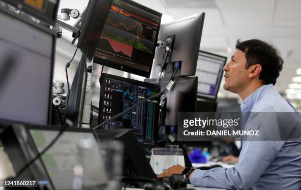Trader Jose Prieto works on his trading station in Bogota, on July 12, 2022. - The euro struck parity with the dollar for the first time in nearly 20...