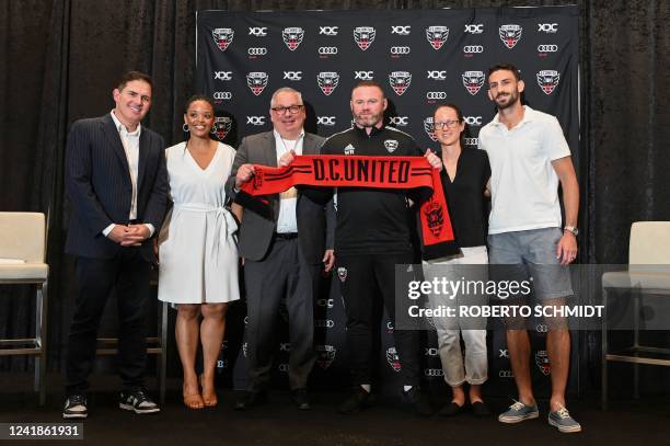 British soccer star Wayne Rooney poses with club owners, staff, management, and players during a press conference where it was announced that Rooney...