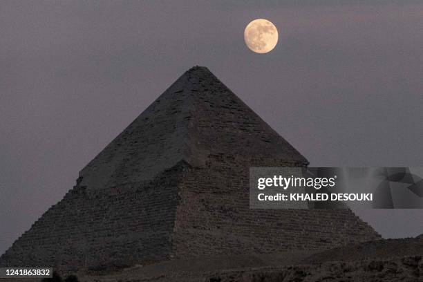 The waxing gibbous moon rises over the Pyramid of Khafre at the Giza Pyramids necropolis on the southwestern outskirts of the Egyptian capital on...