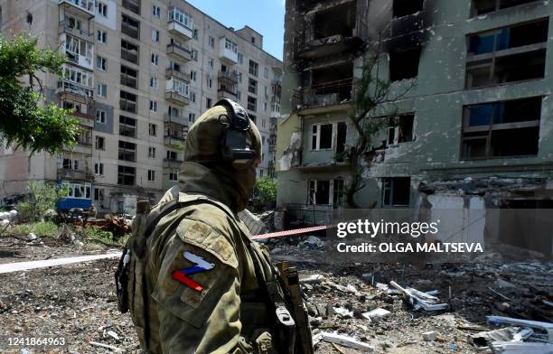 Russian serviceman patrols a destroyed residential area in the city of Severodonetsk on July 12 amid the ongoing Russian military action in Ukraine.