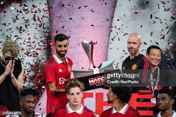 Manchester United's manager Erik ten Hag and Bruno Fernandes hold the trophy after winning 'The Match Bangkok Century Cup 2022' pre-season soccer...