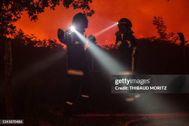 Firefighters attempt to control a forest fire spread on the communes of Landiras and Guillos, southwestern France, on July 13, 2022. - A fire in...