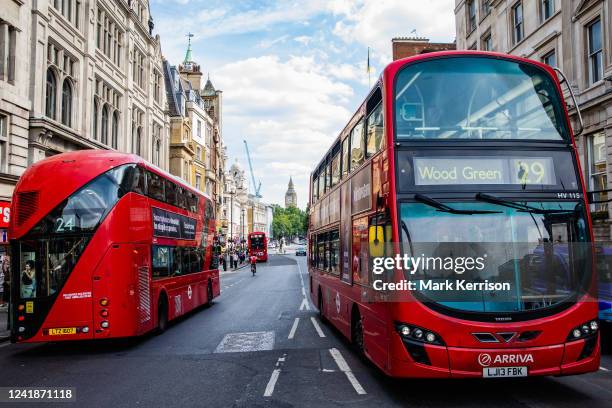 Red double-decker buses pass along Whitehall on 11th July 2022 in London, United Kingdom. Transport for London is looking to save £400 million by the...