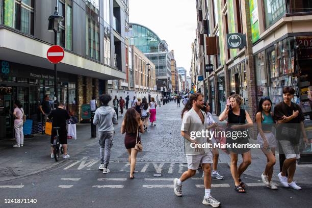 People pass along Berwick Street in Soho on 11th July 2022 in London, United Kingdom. Berwick Street has seen major redevelopment in the past decade,...