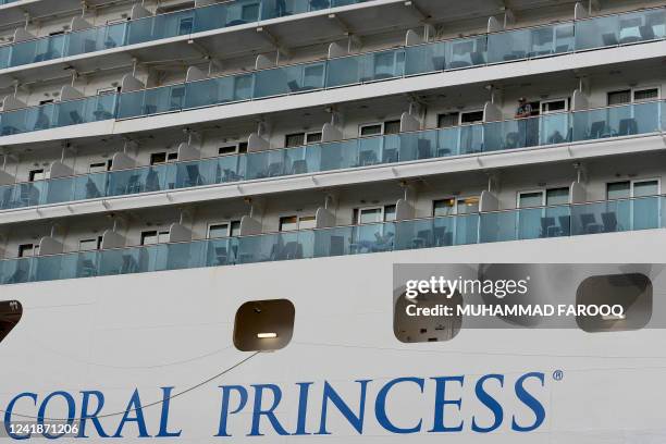 Man looks out from the Coral Princess cruise ship docked at the International Terminal on Circular Quay in Sydney on July 13, 2022. - The Coral...
