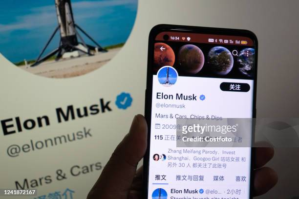 Photo taken on July 13, 2022 shows a Netizen in Shanghai, China, following Elon Musk's twitter page through his mobile phone and smart TV. Both Musk...