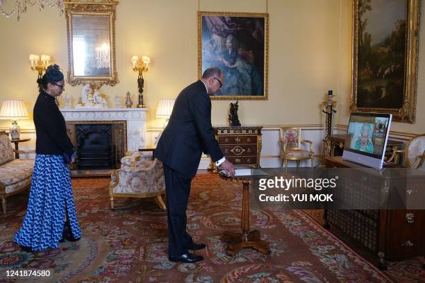 Britain's Queen Elizabeth II in residence at Windsor Castle, appears on a screen via videolink, during a virtual audience to receive High...