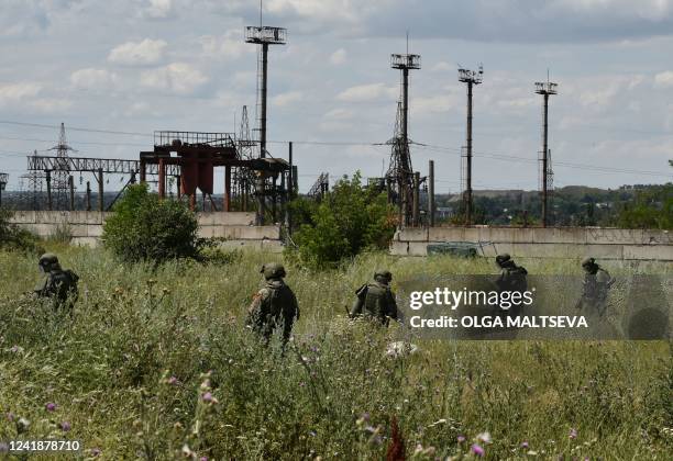 Russian demining team members work to clear an area in the city of Mariupol on July 13 amid the ongoing Russian military action in Ukraine.