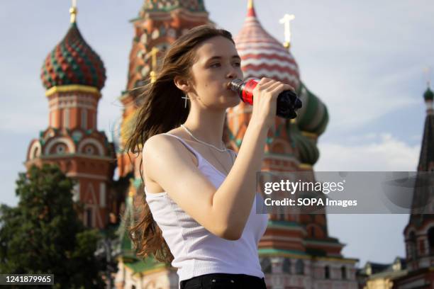 Russian girl drinks Coca-Cola. The Coca-Cola company announced it would not produce or sell its products in Russia. The company owns such brands as...