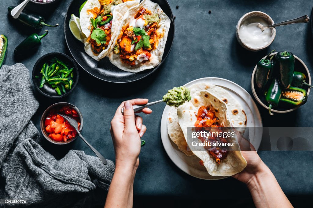 Donna che prepara gustosi tacos vegani