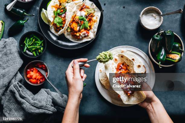 vrouw die smakelijke veganistische taco's voorbereidt - taco stockfoto's en -beelden