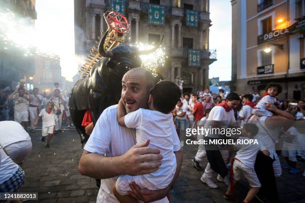 Man wearing a costume of "Toro de Fuego" chases people during the San Fermin Festival in Pamplona, northern Spain, on July 13, 2022.