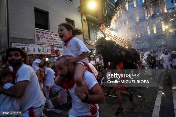 Man wearing a costume of "Toro de Fuego" chases people during the San Fermin Festival in Pamplona, northern Spain, on July 13, 2022.