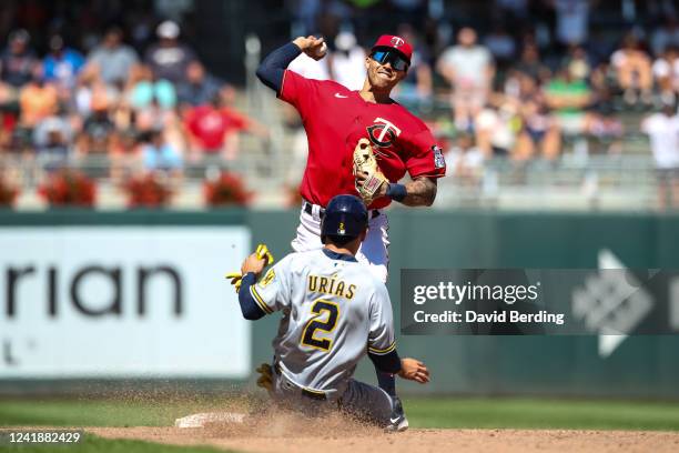 Luis Urias of the Milwaukee Brewers is out at second base as Carlos Correa of the Minnesota Twins turns a double play in the ninth inning of the game...