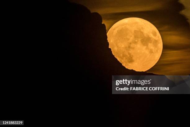 Full super moon, rises behind a mountain in the Swiss Alps, seen from Chexbres, western Switzerland, on July 13, 2022.