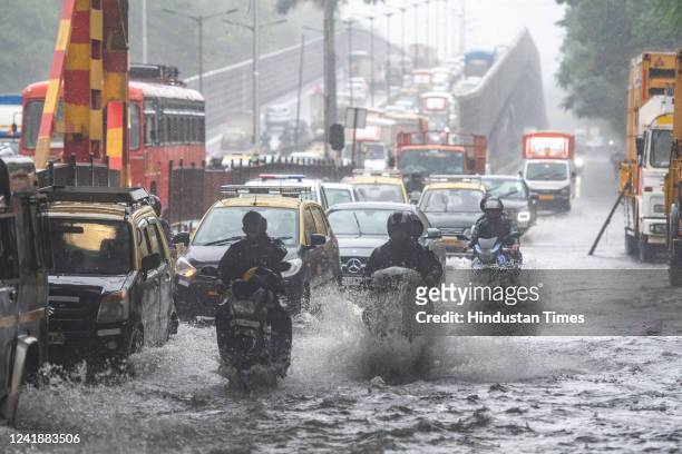 Vehicles wade through waterlogged street after heavy rain at Gandhi Market, Sion on July 13, 2022 in Mumbai, India. The India Meteorological...
