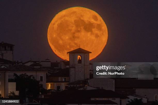 Supermoon rises behind Saint Peter church in L'Aquila, Italy, on July 13, 2022.