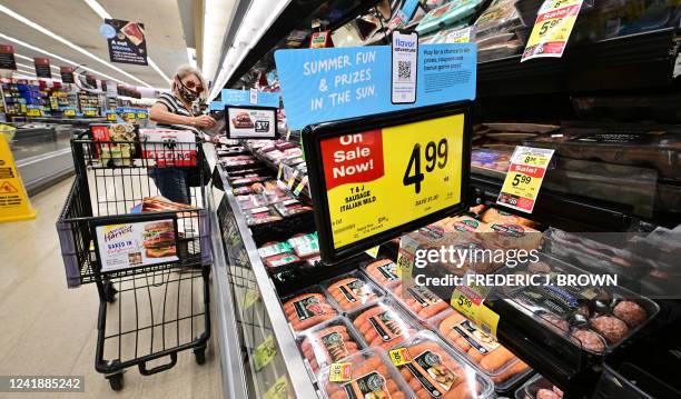 Woman checks an item from the meat department while grocery shopping at a supermarket in Alhambra, California, on July 13, 2022. US consumer price...