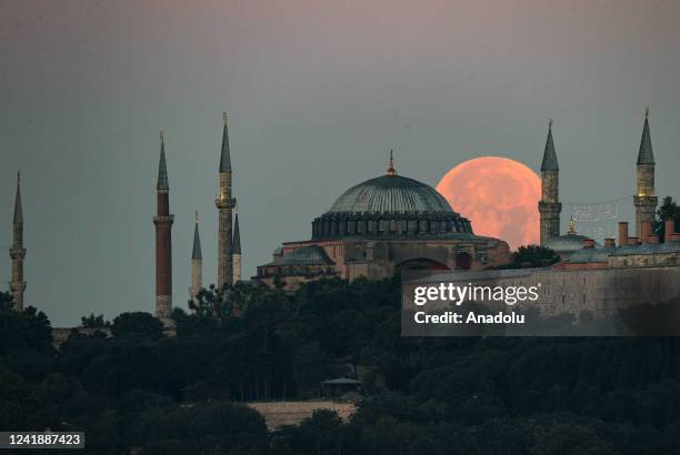 Full moon rises over the Hagia Sophia Grand Mosque and Blue Mosque in Istanbul, Turkiye on July 14, 2022.