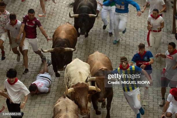 Participants run ahead of Miura bulls during the "encierro" of the San Fermin festival, in Pamplona, northern Spain on July 14, 2022. On each day of...