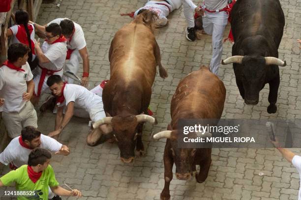 Participants run ahead of Miura bulls during the "encierro" of the San Fermin festival, in Pamplona, northern Spain on July 14, 2022. On each day of...