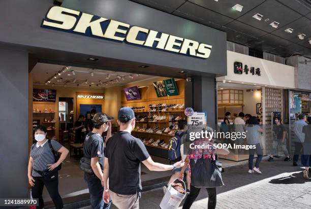 Pedestrians walk past the American lifestyle and performance footwear brand Skechers store in Hong Kong.