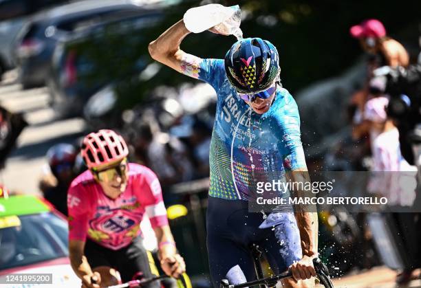 Israel-Premier Tech team's British rider Chris Froome cools down with water as he cycles the ascent of the Col de la Croix de Fer during the 12th...