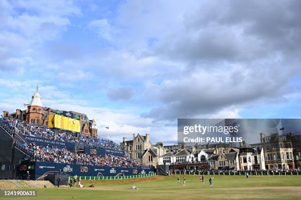 Players putt on the 18th green in the evening sunshine during the opening round on the first day of The 150th British Open Golf Championship on The...