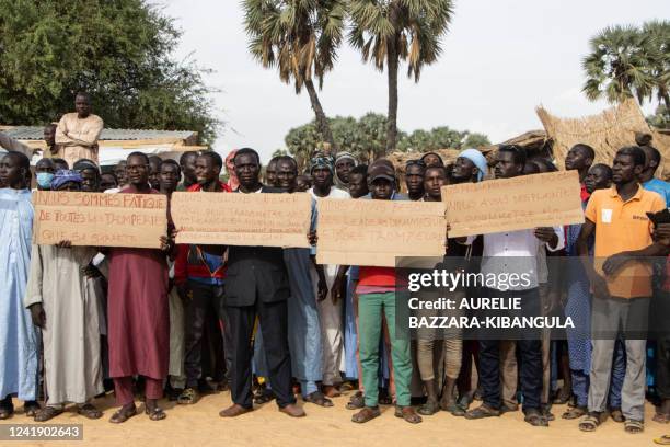 Demonstrators hold placards where one reads "we need dynamic leaders and not liars" protesting against the lack of food pensions during a visit of...