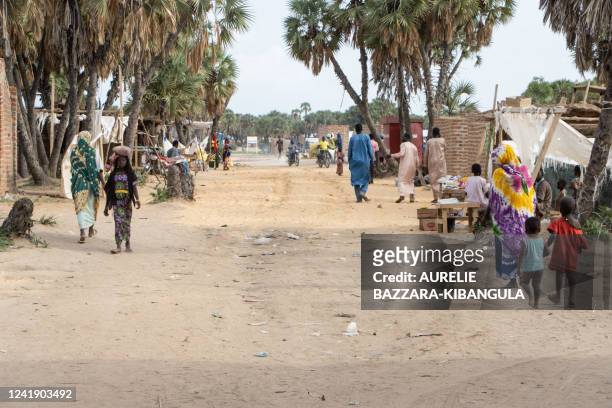 Pedestrians walk in the central alley of the Kalambari refugee camp 30km near N'Djamena on July 14, 2022. - The Kalambari refugee camp hosts 7 600...