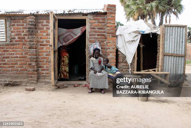 Two girls share a gombo sauce dish at the Kalambari refugee camp 30km near N'Djamena on July 14, 2022. - The Kalambari refugee camp hosts 7 600...