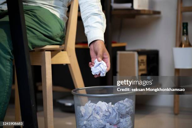 woman hand throwing crumpled paper in basket - crumpled paper ball stock-fotos und bilder