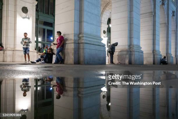 Migrants seek shelter in the hallway after arriving alongside other migrants at Union Station in Washington, D.C. On July 12 following a bus ride...