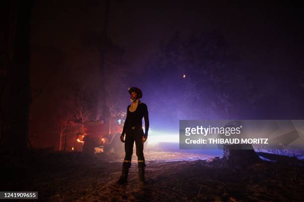 Firefighter stands as a wildfire spreads in the area close to the beach of Cazaux lac, near La Teste-de-Buch, southwestern France, on July 15, 2022....